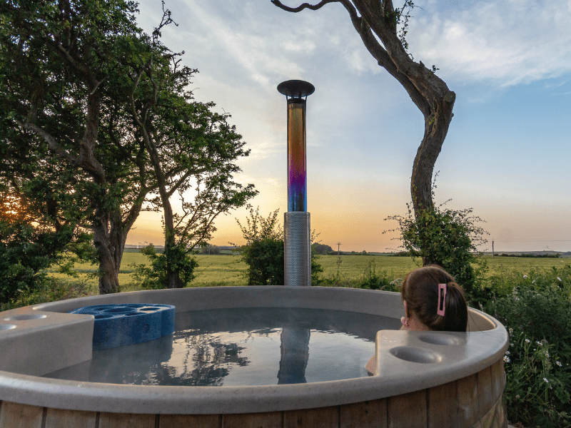Untitled design-2 Woman relaxing in wood-fired hot tub with North Yorkshire countryside views