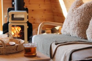 Shelter Pod interior coffee table with cup of tea and wood-burning stove, North Yorkshire glamping